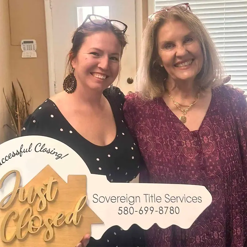 Brittany McConnell with a client holding a “Just Closed” sign on closing day